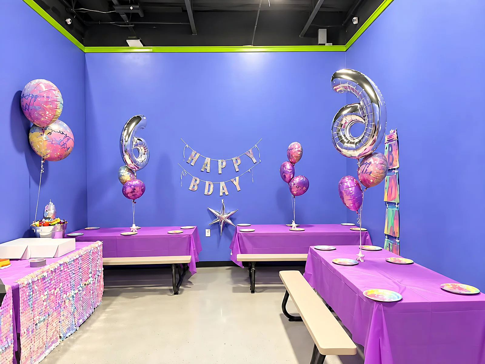 Decorated birthday party room with purple tables and balloons